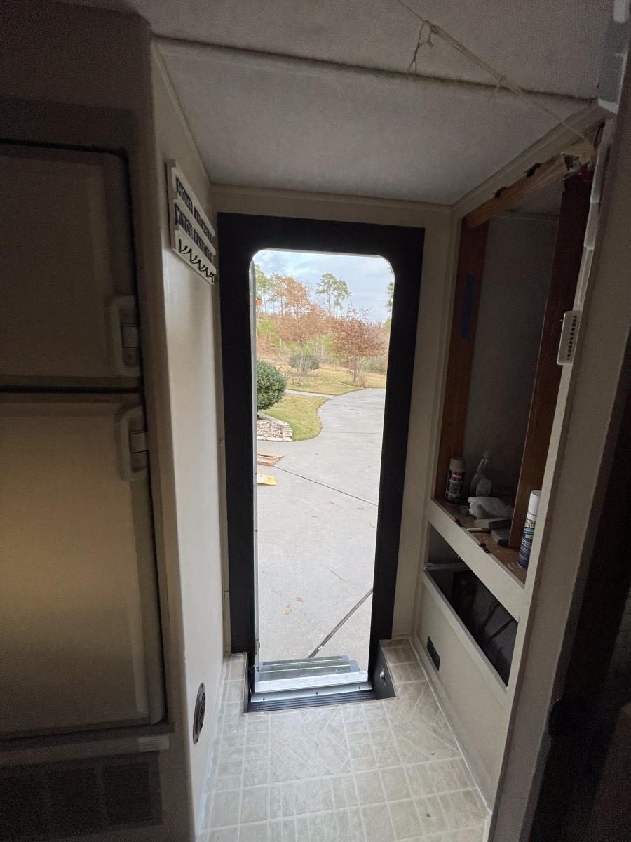 removed broken old plastic door frame, insulated and trimmed out with lumber, then painted it black.