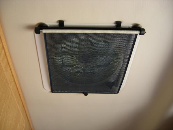 Retractable window shade over Maxx air vent to help block light for sleeping while still allowing ventilation.