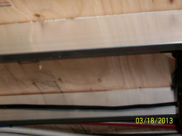 Route the wire along the aluminum floor joist that runs between the front and rear of the under storage compartment.