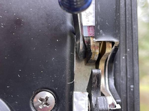 Showing wear on inner plate where the pin was previously rubbing against the plate when people tried to slam it closed.