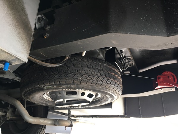 Spare tire in final position. Winch cable lifts it into position and two 1/2” nuts provide the final mounting.