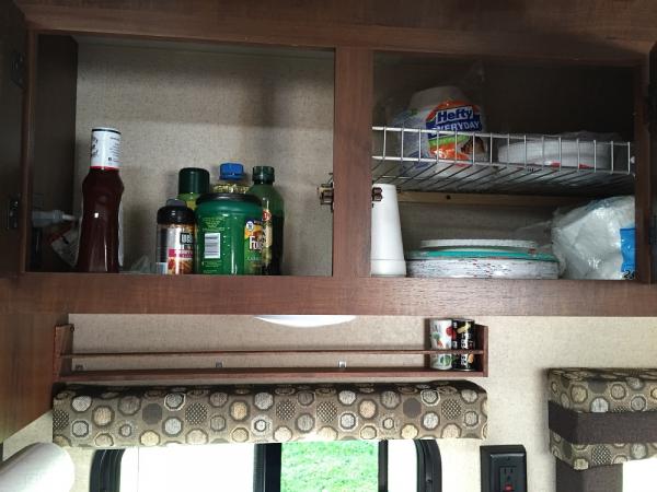 Spice rack above the window and shelves in the overhead cabinets.