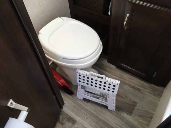 Stool folds flat and tucks next to toilet.