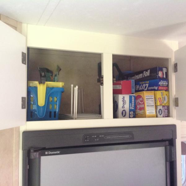 Storage above fridge.  Paper products stay in cabinet year round