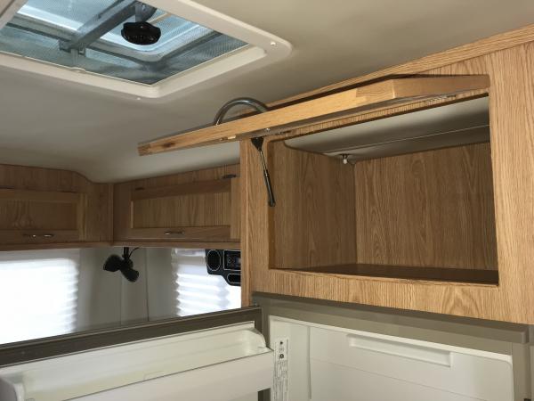 Storage above refrigerator.  Microwave would go here and has a 120 volt outlet in the back.