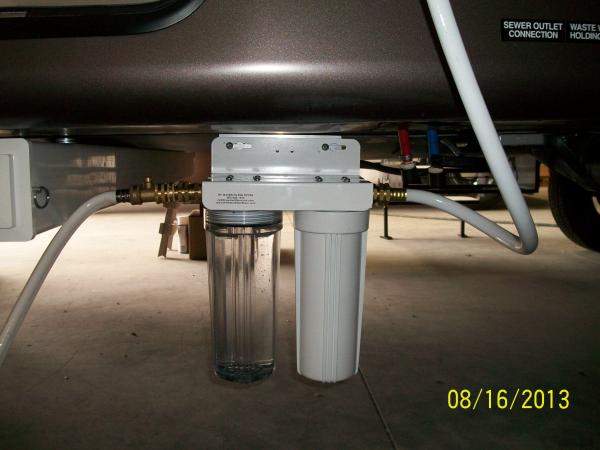 The Dual Filter Mount slides onto bolts on an aluminum angle bracket that is fastened to the RV back under the RV at the Frame.  This sets it back und