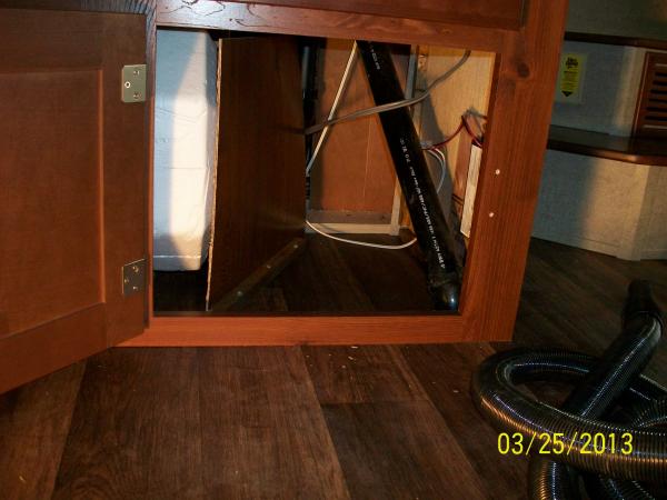 The piece of divider paneling removed from in the Lower TV Cabinet Mod fits perfectly in front of the Water Heater plumbing as protection from items s