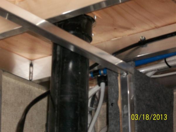 The wire is routed along the floor joist, and passes above the storage compartment wall, behind the toilet pipe, and over to the Power Distribution Pa