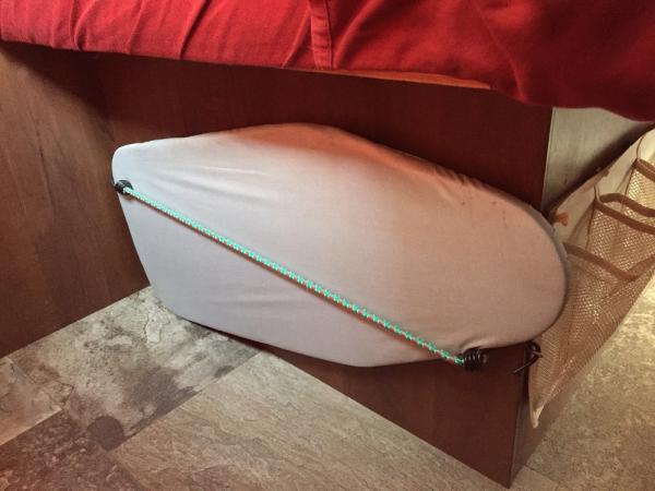 Using 2 eye hooks and a bungee cord I was able to store my tabletop ironing board under the bed.