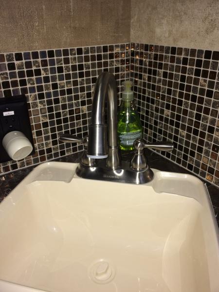 We installed a smart tile backsplash in the bathroom, as well as a Glacier Bay gooseneck faucet so you can actually get your hands under the water! Co