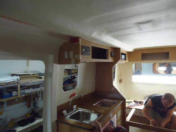 Week 2 Kitchen. Solar controller on overhead cabinet, stainless sink and faucet, stainless cooktop not yet installed.